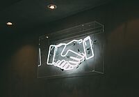 Neonlichter in Form von schüttelnden Händen